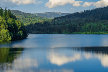 Obraz premium Mountain lake in clear weather, with the sky reflected in the water.