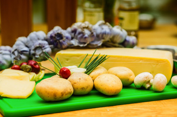 cheese and ingredients for preparing food on a wooden table.