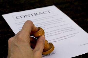 A man hand signs and approves contract