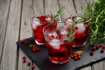 Refreshing drink with cranberries and rosemary on wooden background, selective focus, copy space
