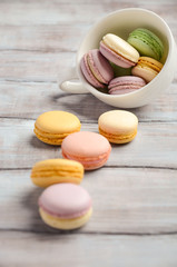 Colorful French macaroons on wooden background, selective focus, copy space