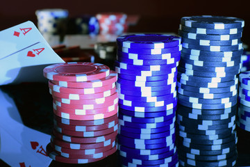 Pair of aces in pocket pair and poker chips. Black surface, horizontal view.