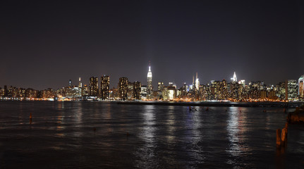 Fototapeta na wymiar New York Skyline reflected in water, view at night from Brooklyn
