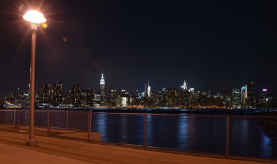 Fototapeta na wymiar New York Skyline reflected in water, view at night from Brooklyn