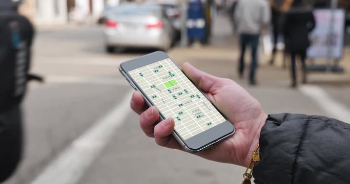 A woman uses a smartphone to observe ride sharing traffic patterns on an interactive map in a city.	 	