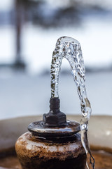Naklejka na ściany i meble Close up water drops flowing from fountain