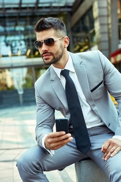 Businessman on street texting on smartphone