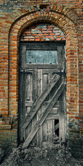 Fototapeta na wymiar Old wooden door in an old brick building