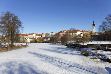 Snowy winter royal medieval Town Pisek above the frozen river Otava, Czech Republic 