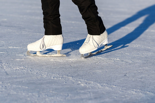 Ice Figure Skates on Woman Legs. Closeup Ride View.