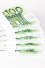 Close-up of Stacks of 100 Euro Banknotes isolated on white background