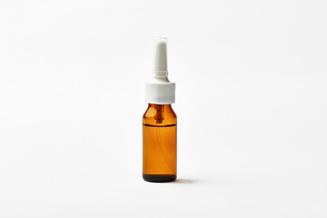 Nasal spray on white background. Transparent glass bottle with liquid. Forget about rheum.