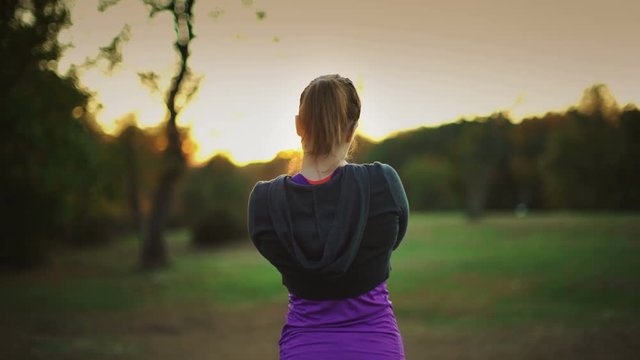 Post workout woman at a park at sunset