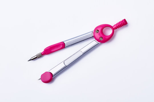 Pink pair of drawing compasses. Stationery on white background. Equipment of an architect.