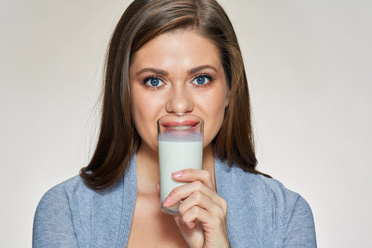 Smiling young woman drinling milk.
