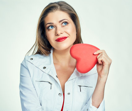 Thinking woman holding red heart.