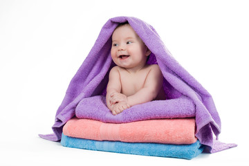 Newborn baby smiling lying on a stack of towels