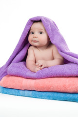 Newborn baby lying on a stack of towels