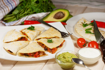 Fototapeta na wymiar Quesadilla with chicken, served with guacamole or salsa sauce