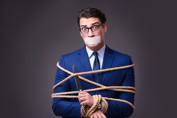 Businessman taken hostage and tied up with rope