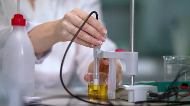 Chemical potentiometer measure acidity of liquid in lab. Lab woman doing laboratory testing in lab. Close up of laboratory equipment working. Laboratory testing of liquid in laboratory glassware