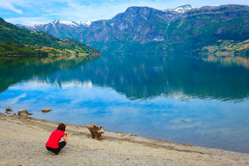 Tourist taking photo at norwegian fjord