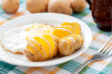 Baked potatoes and yellow eggs on a white plate