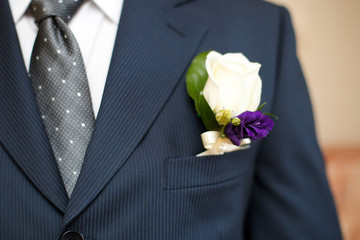 Colorful wedding boutonniere on suit of groom