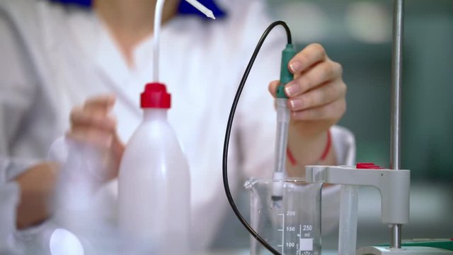 Lab worker cleaning laboratory equipment. Scientist woman working in lab. Close up of scientist working with equipment. Lab woman working in lab. Female scientist working with laboratory equipment