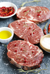 Raw fresh meat Ribeye Steak with rosemary, pepper, salt and olive oil
