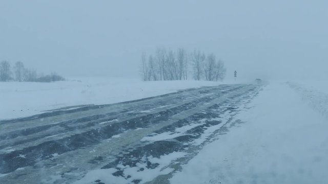 Cars on winter road at blizzard, 4k
