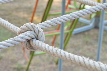 Rope knot line tied together with playground background,as a symbol for trust, teamwork, coordination or collaboration.