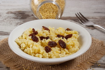 Cooked millet groats on white plate, healthy food and nutrition