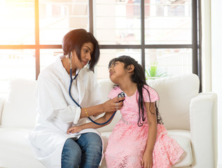 indian female doctor treating young patient