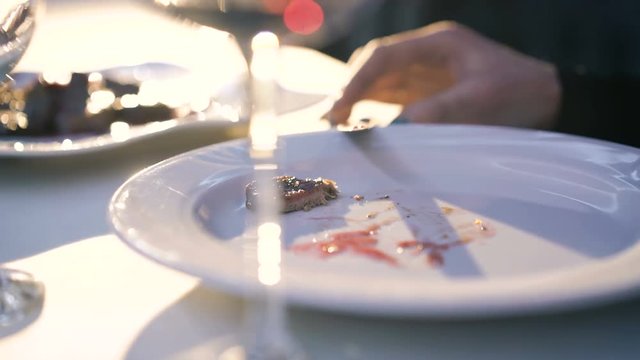 Close up of woman's hands cutting dish ort on plate in restaurant 4K