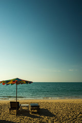 Fototapeta na wymiar Beach chairs on the white sand beach with cloudy blue sky