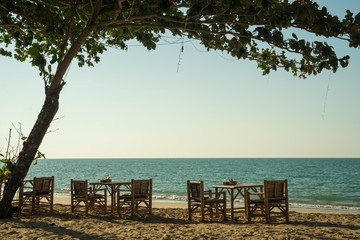Fototapeta na wymiar Vacation in tropical countries. Beach chairs, umbrella and palms
