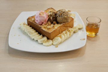 Honey toast in a white dish on a wood table, selective focus