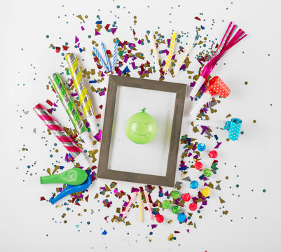 Photo frame with party confetti, balloons, noisemakers and decor