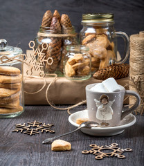 Cup of cocoa on a gray background. Cookies in glass jars