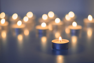 Flame of many candles burning on the background blue color