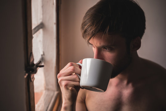 Pensive man drinking from a cup