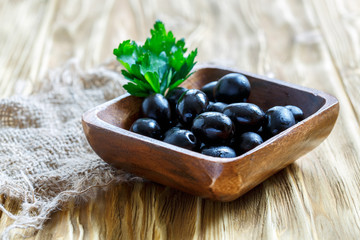 Black olives in a wooden bowl.