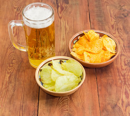 Lager beer and two various potato chip in ceramic bowls