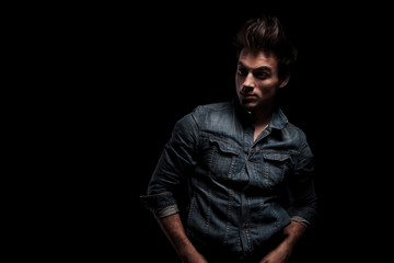 Obraz premium dramatic young man standing with hands in pockets