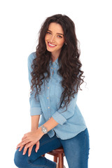 portrait of a seated smiling curly woman