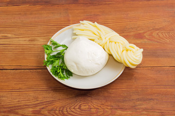 Two kinds of mozzarella cheese and parsley on a saucer