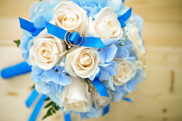 bridal bouquet and newlyweds rings. marriage rings on the white roses