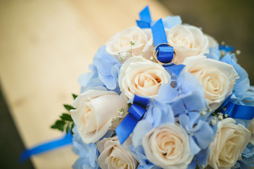 bridal bouquet and newlyweds rings. marriage rings on the white roses