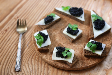 snack black caviar on a wooden background